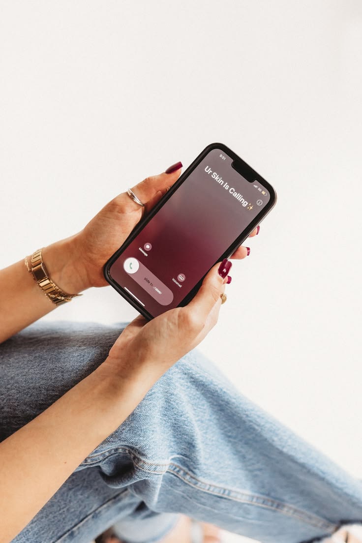 Handen die een telefoon met een merkscherm vasthouden
